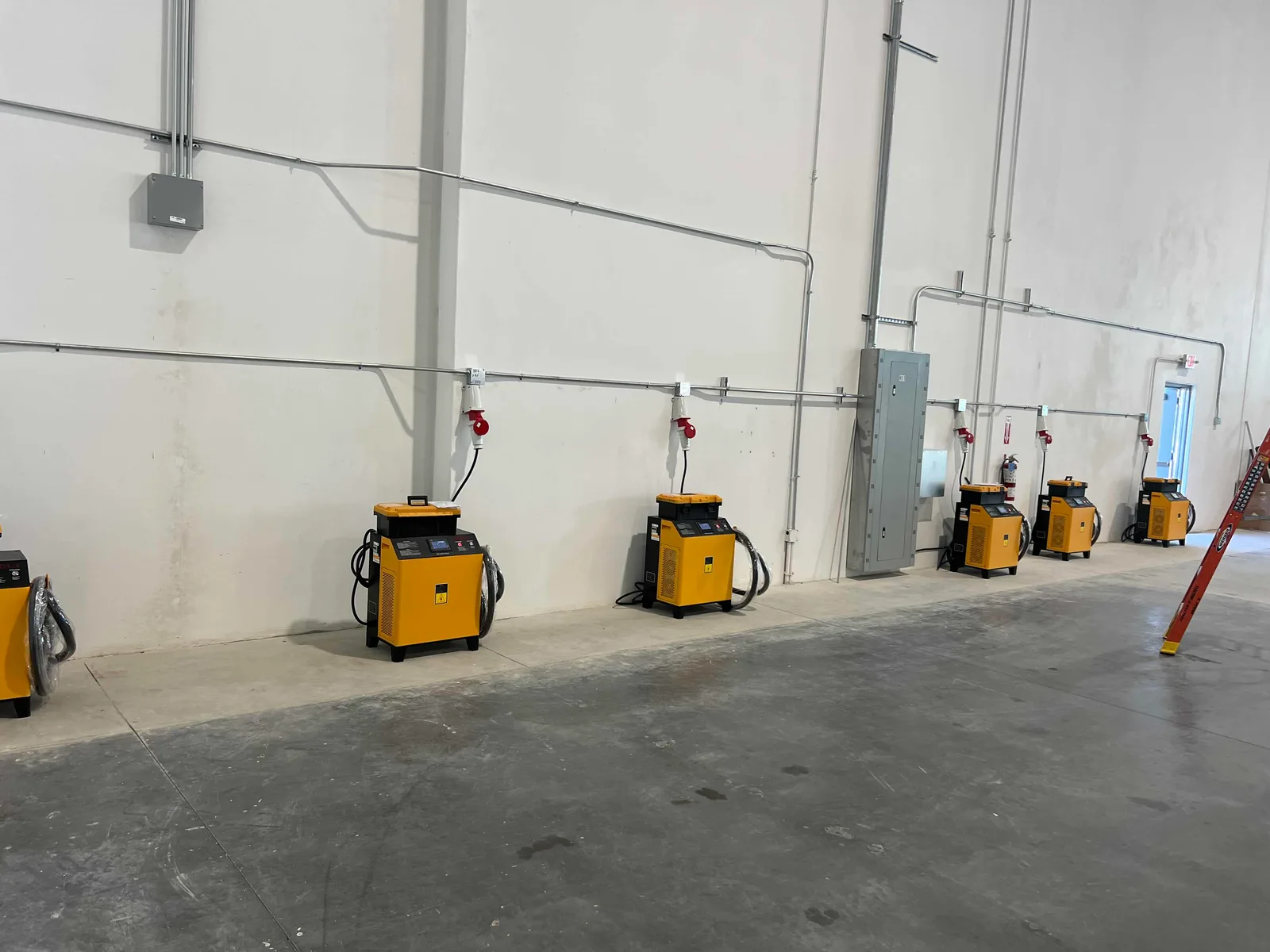 A row of charging units along a warehouse wall