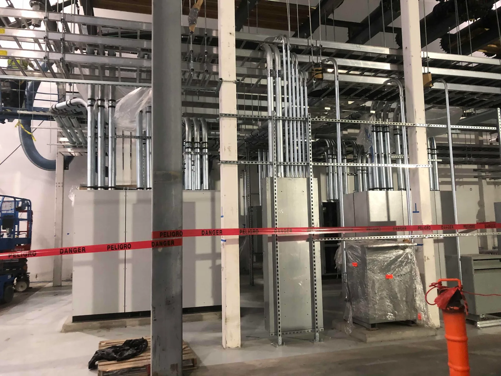 Conduit runs and electrical equipment along an industrial interior